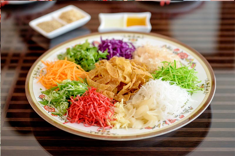 Yee Sang or Lou Hei or Yu Sheng is a popular festive dish in Malaysia and Singapore, eaten during Chinese New Year for prosperity and luck.